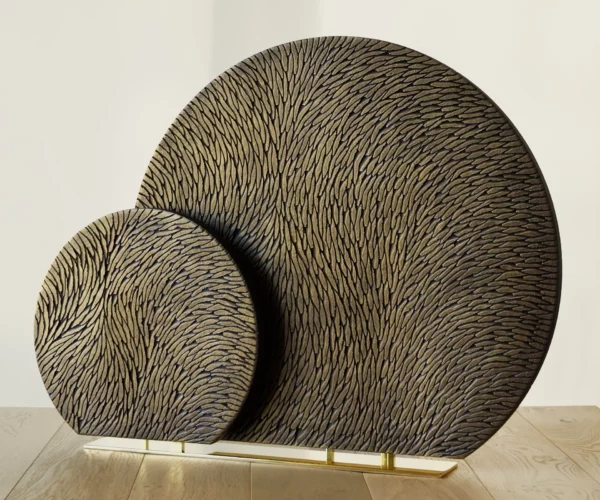 Vue de face d'une sculpture double sur un même socle en laiton poli miroir. Les deux sculptures sont des cercles tronqués de diamètre différents. Elles sont toutes les 2 en plâtre sculpté patiné bronze doré.