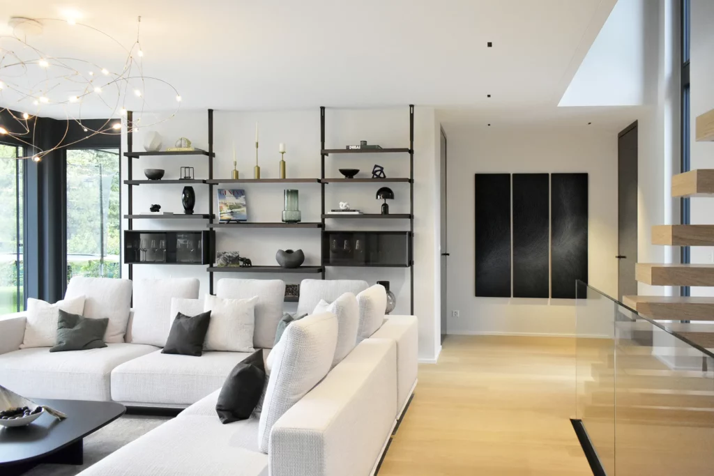 salon d'une villa contemporaine à proximité du lac léman en Suisse, un triptyque sur mesure de l'atelier Mylène Mai est accroché au mur de la pièce. Les tons de la pièce sont sobres, neutres, épurés.