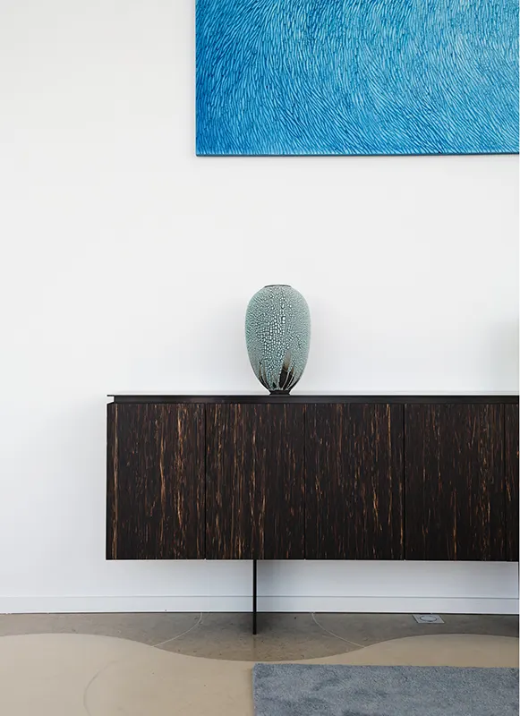 Villa contemporaine aux murs blancs sur la presqu'ile de Saint Jean Cap Ferrat, une oeuvre d'art sur mesure de l'artiste Mylène Mai est accroché au dessus d'une console moderne. L'oeuvre est en plâtre sculpté, dans des teintes de bleus doux et azur.