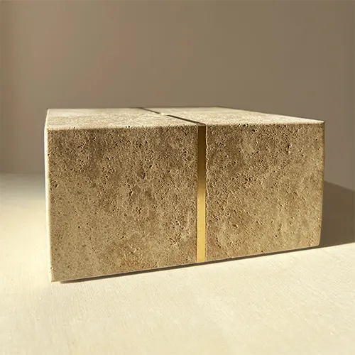 Le socle seul d'une sculpture est photographié, on voit un assemblage précis et technique de deux matières, la pierre de Bourgogne et le laiton.