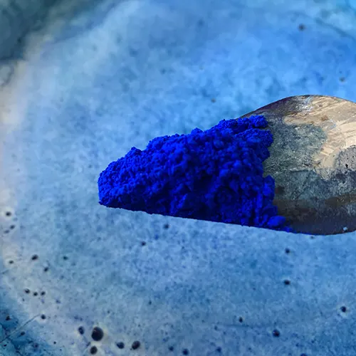 Pigment bleu outremer en zoom sur une spatule à l'atelier de l'artiste Mylène Mai, sculpteur d'oeuvres en plâtre et pierre